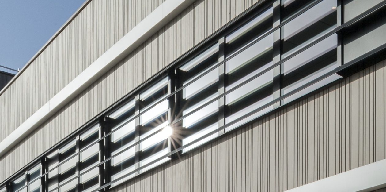 Head office with two levels. Siding's implementation, installed vertically. Siège social CEPROM Le dôme de Rentilly, ZAE du Gué Langlois 24 Avenue du Gué Langlois 77600 Bussy-Saint-Martin. Panels Argeton Altivo Gris Argent, Noir bazalt, Rouge, Altivolite.